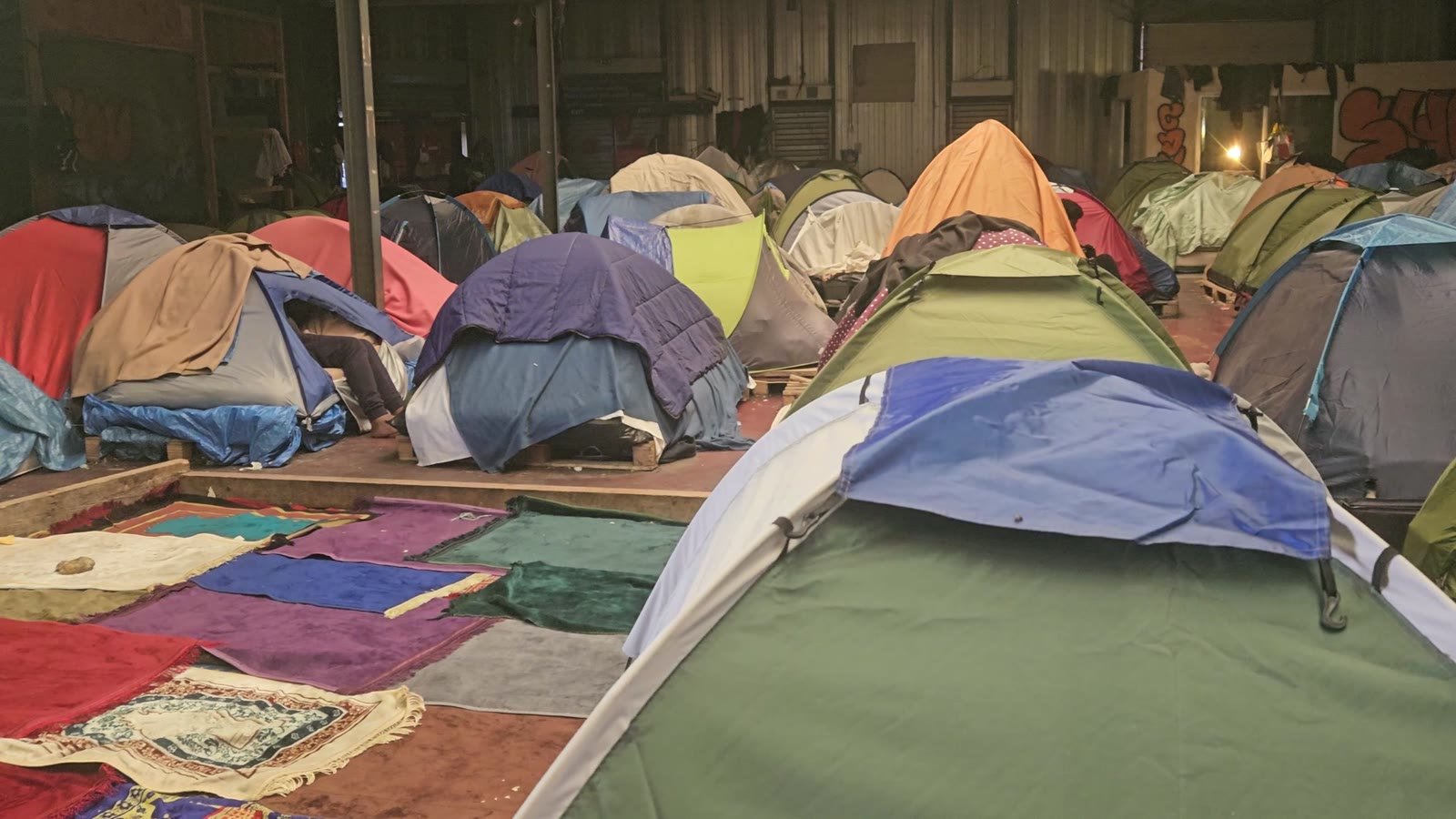 Around 100 tents inside a warehouse camp near Calais.