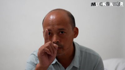 A Chinese man in Colombia with his pointer finger in the air