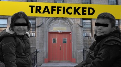 Two young children with their identities redacted in front of a building